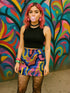 Psychedelic high waisted mini skirt for women featuring a trippy swirl print in yellow, pink, purple, and blue. Fitted bodycon silhouette with 1.5” elastic waistband, made from eco-friendly polyester and spandex blend. Available in sizes S to XL with built-in UPF 50 sun protection and odor-resistant, quick-dry performance fabric. Festival-ready, rave-approved, and styled for bold streetwear and summer outfits.